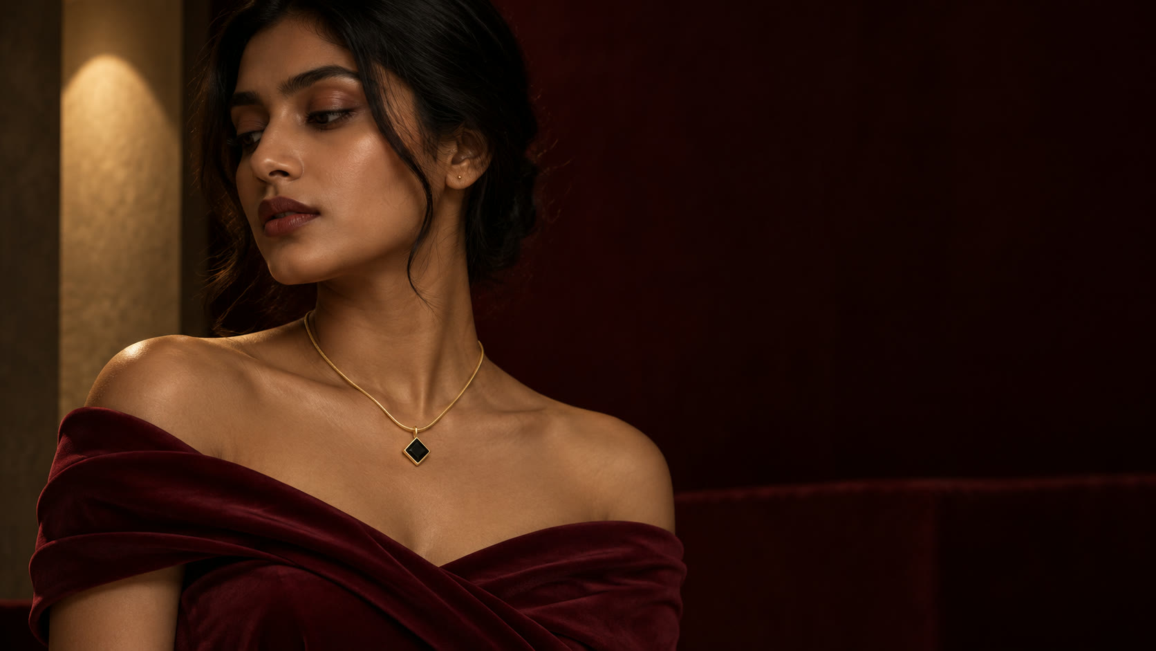 A noir stone pendant necklace worn with evening styling in low light